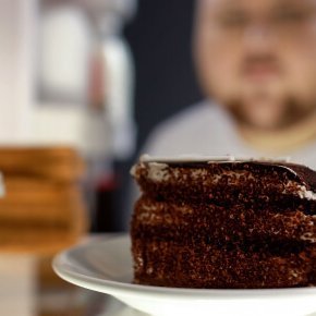 Übergewichtiger Mann schaut in den Kühlschrank